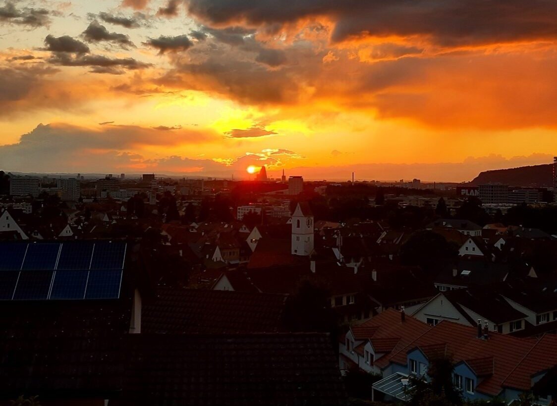Sonnenuntergang über den Dächern von Pratteln mit Blick auf die Dorfkirche – BnB Sunnesite